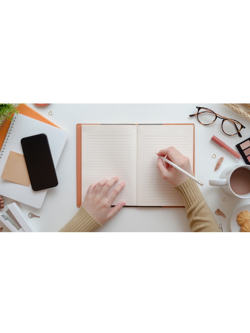 A focused individual writing in a notebook