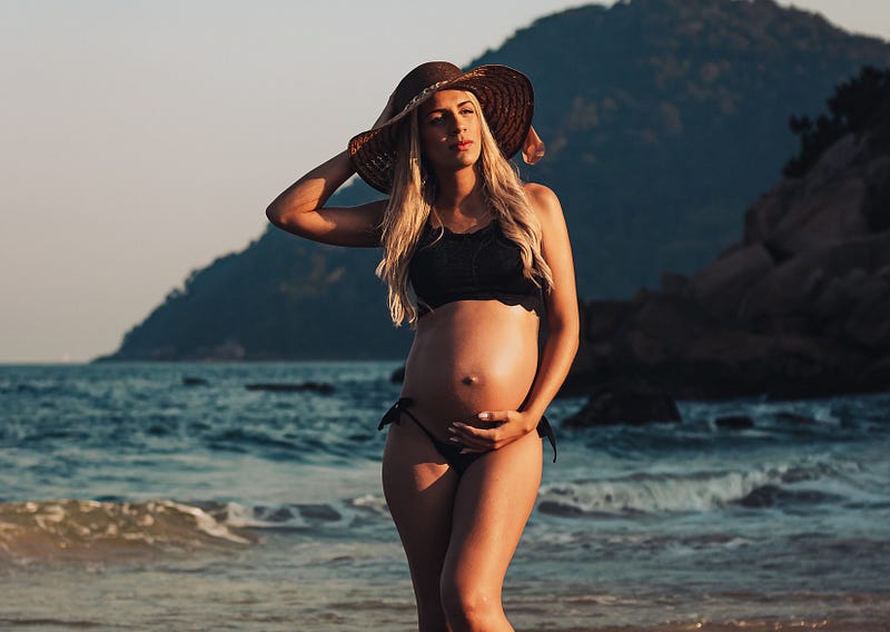 Pregnant woman enjoying a sunny day at the beach